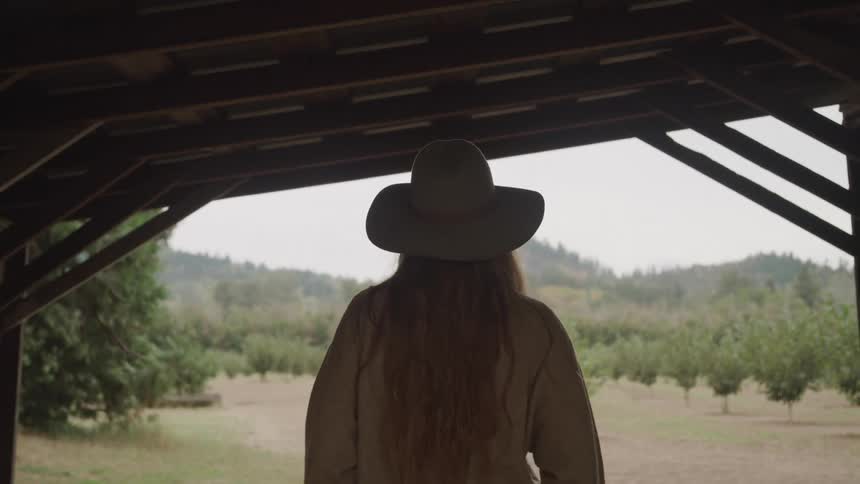 A woman walks towards the crops on the farm