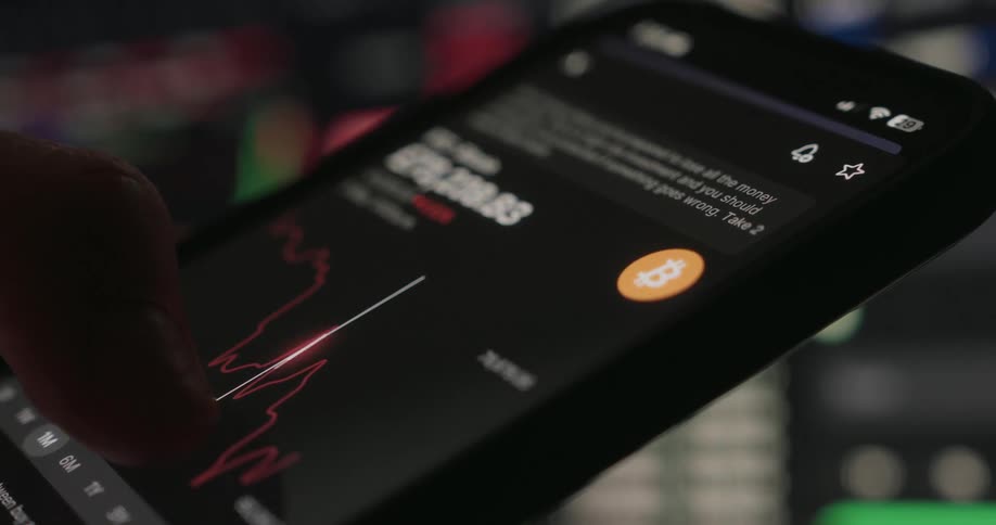 Finger scrolling on cell phone to see the detail of a graph of the value of bitcoins