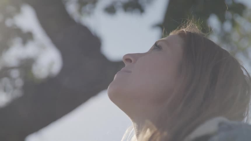 Girl in the middle of nature looking up