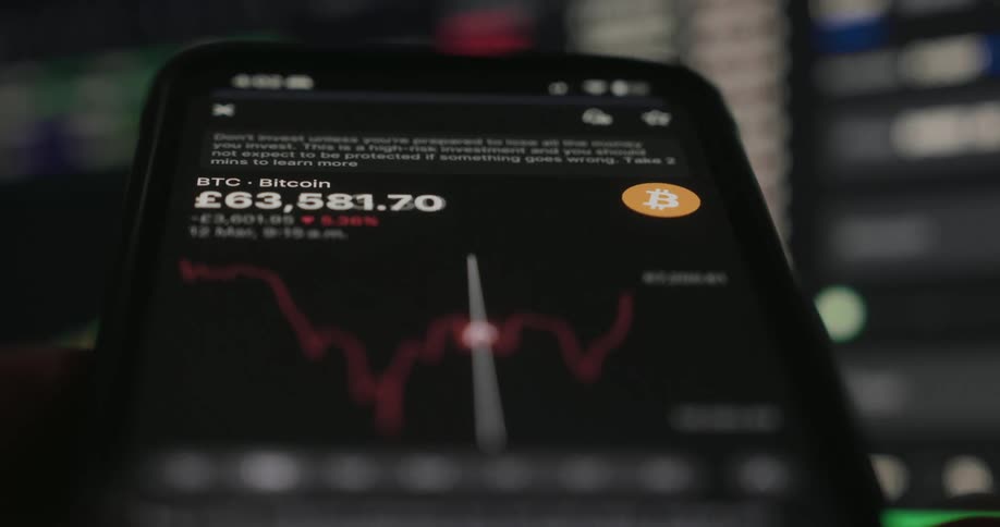 Close up on a phone screen tracking the changing price and fluctuating chart for bitcoin btc in a trading app