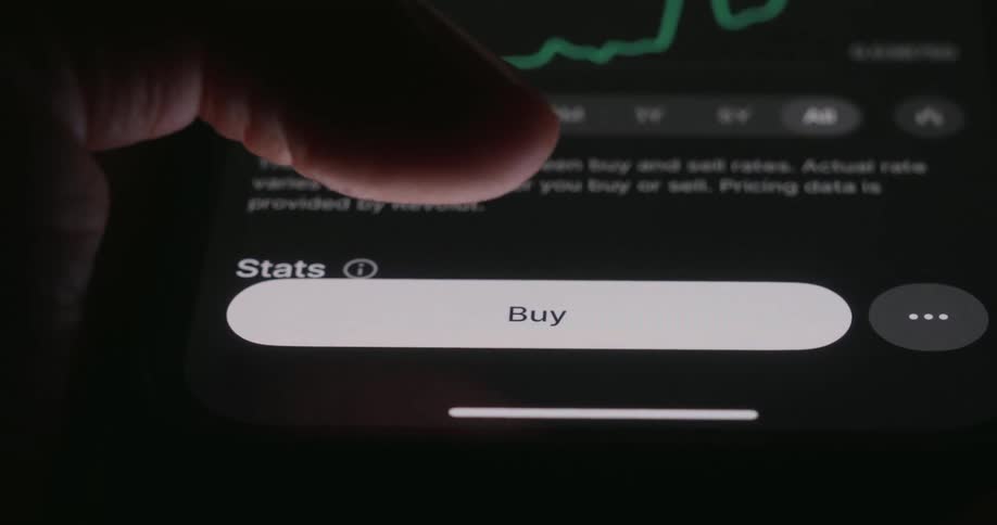 Person taps their smartphone with their thumb to buy a stock