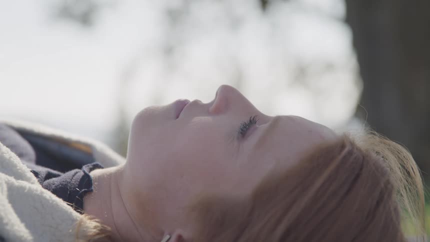 A woman is sleeping on the grass