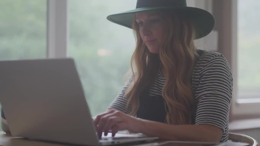 Girl sitting at a table typing on a computer