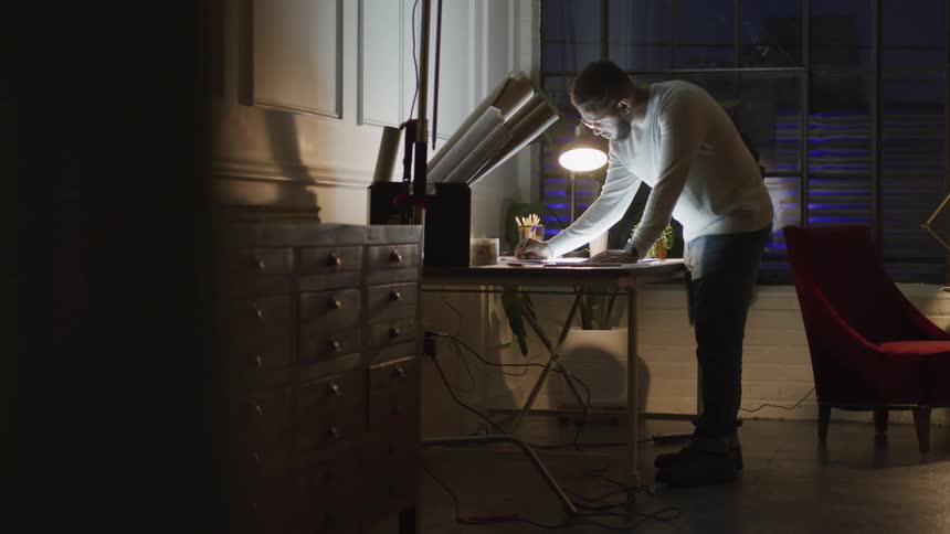 Man standing on drawing at a desk in a home office