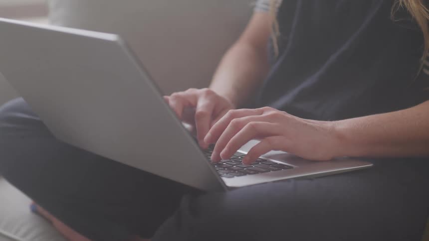 Woman typing on the keyboard of a laptop computer