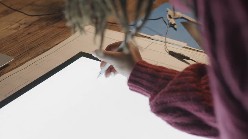 Woman uses a digital pen on a very large lit up tablet