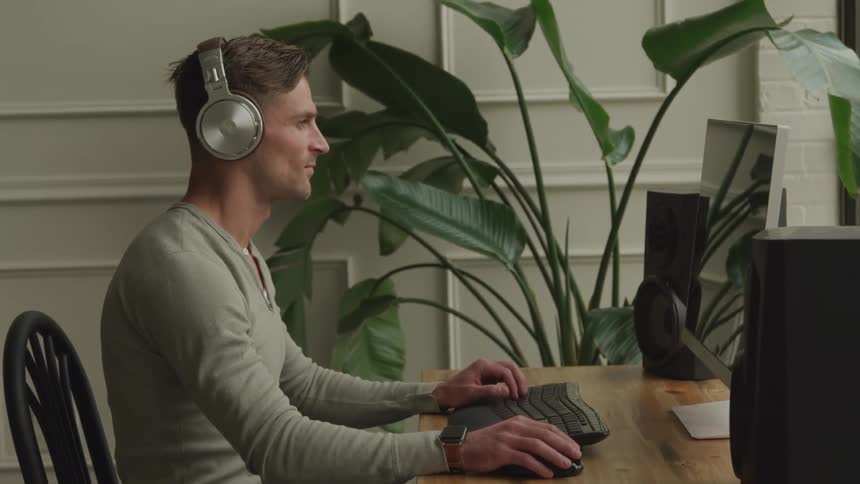 Young man wearing headphones as he sits in front of a computer
