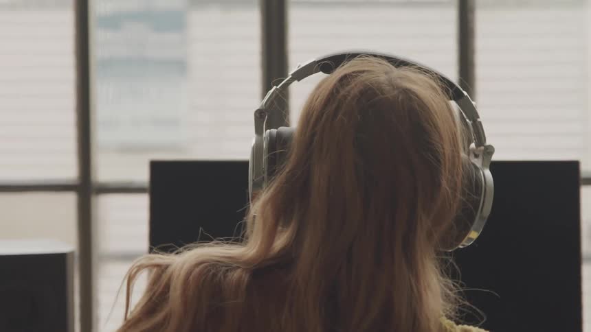 A woman is listening to music and dancing indoors