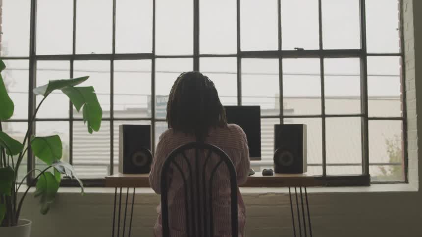 A woman puts on headphones at the computer