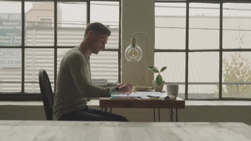 A man working in the office is using a pencil