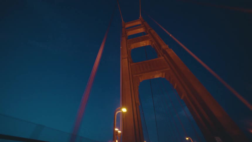 A tall cable bridge reaches into the night sky