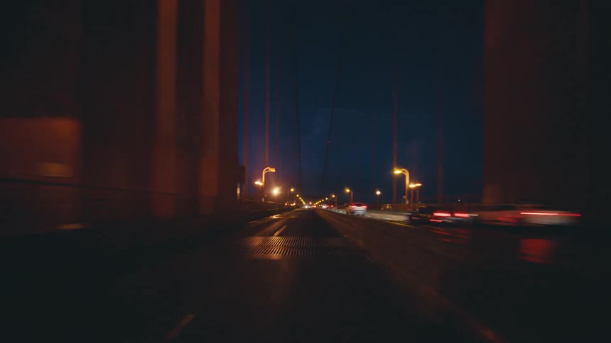Vehicles travel over the bridge at night