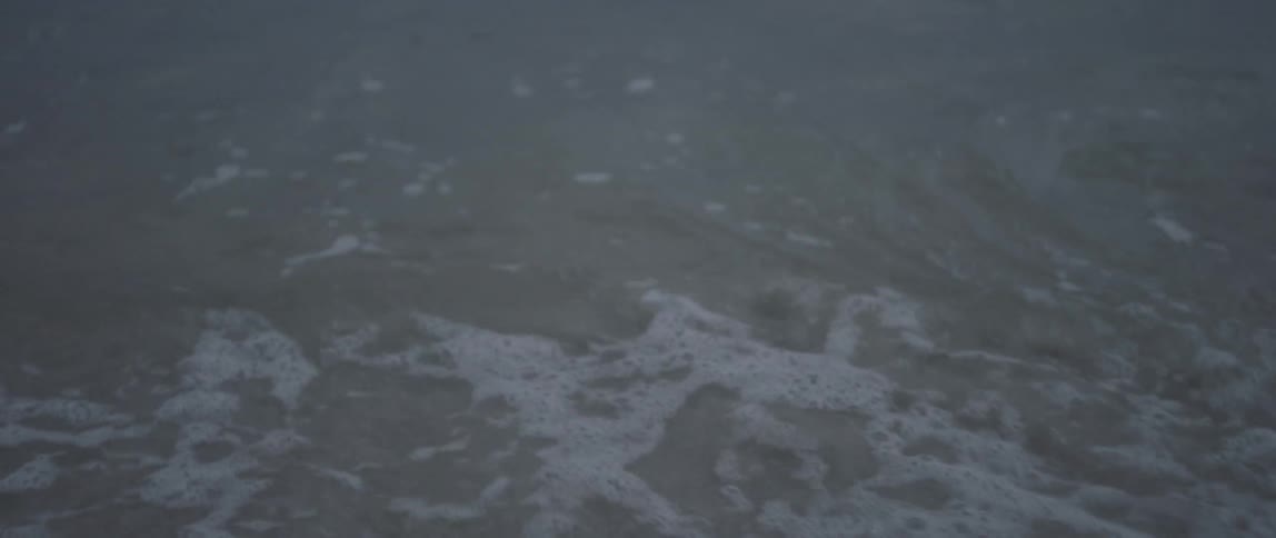 Waves gentle crash onto a beach on an overcast day