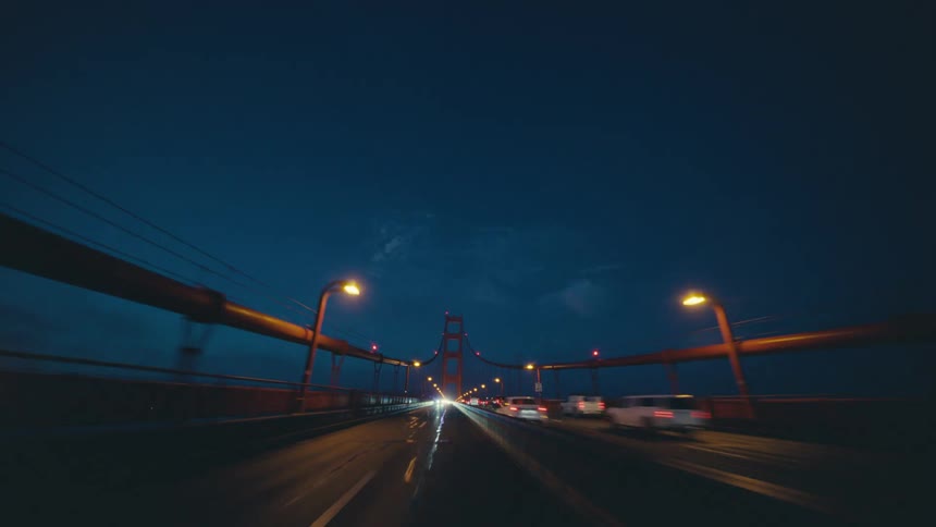 Traffic moves across a highway bridge at night