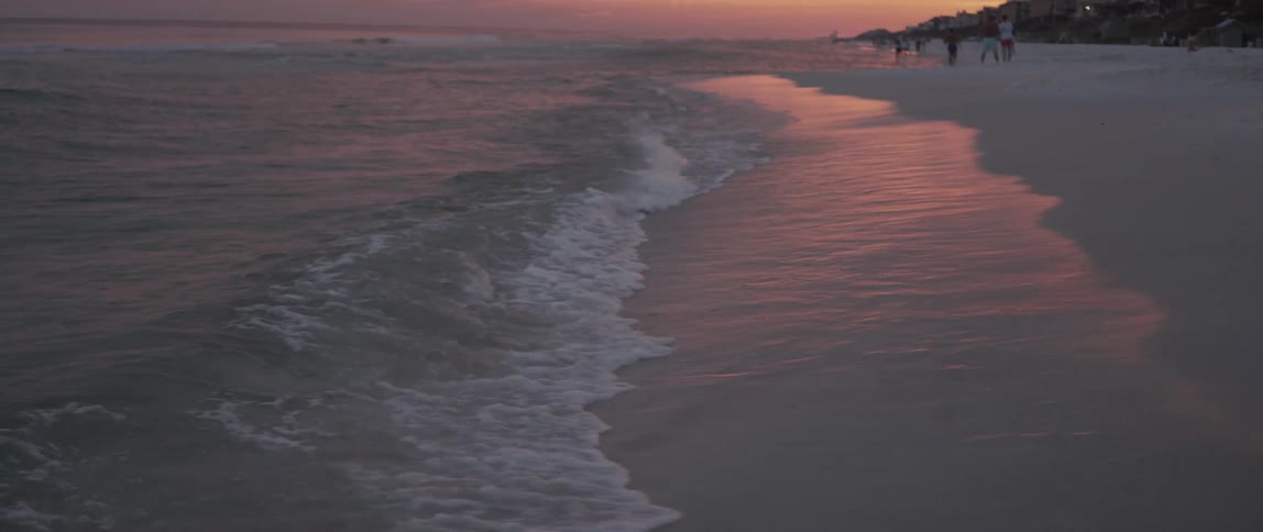 People are on the beach ahead at dawn