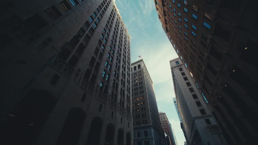 Looking up at tall buildings and towers moving through downtown