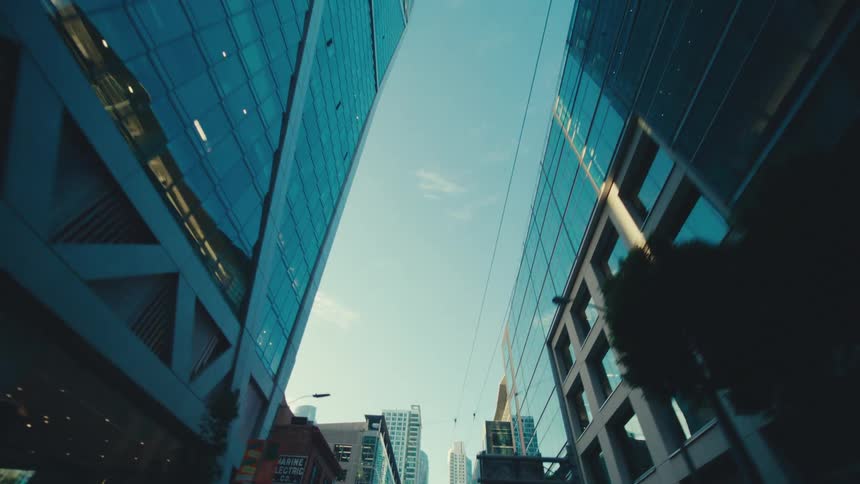 The tall buildings reflect the sunlight in the city