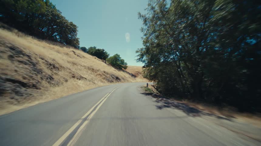 The winding road runs past the hills