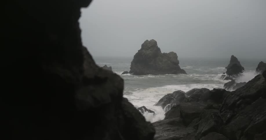A view of the ocean splashing up on large boulders
