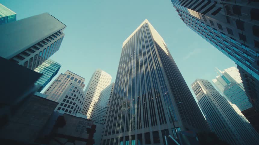 A cluster of skyscrapers reaching towards a clear blue sky emphasizing their height and architectural diversity