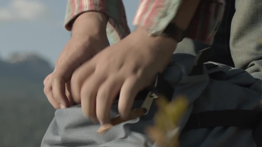 A backpack is unzipped and camera removed