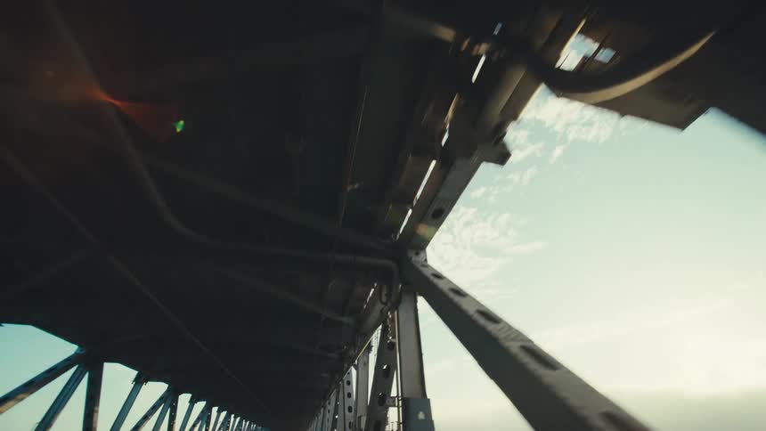 The underside of a metal bridge with triangular supporting braces