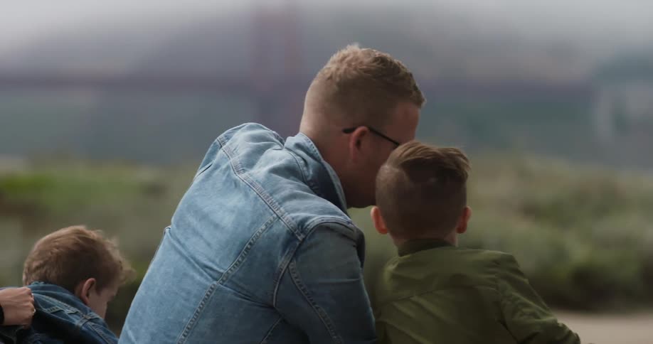 A man with his children sightsee on a windy day