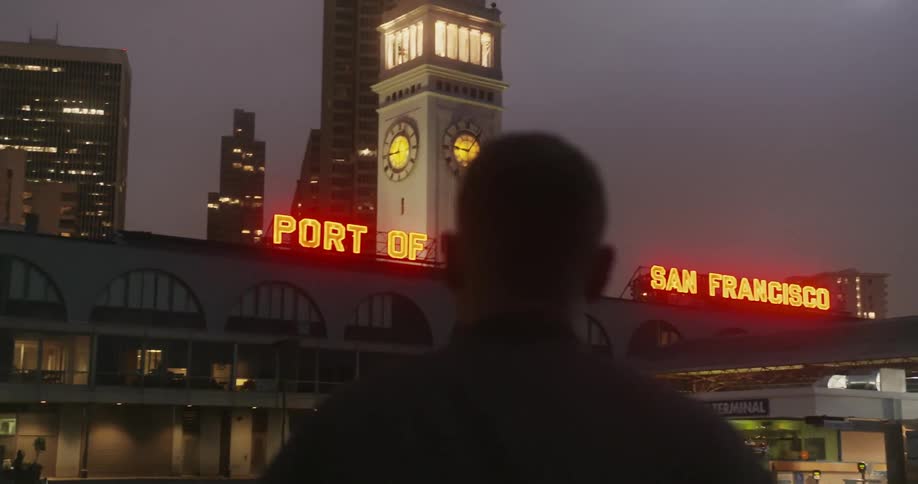 A man is walking towards the port of san francisco at dawn
