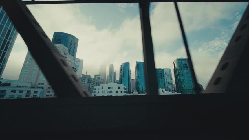 Cars driving over a bridge leaving a downtown city