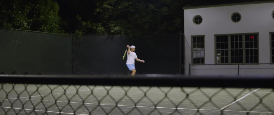 Man hits a tennis ball with his racket