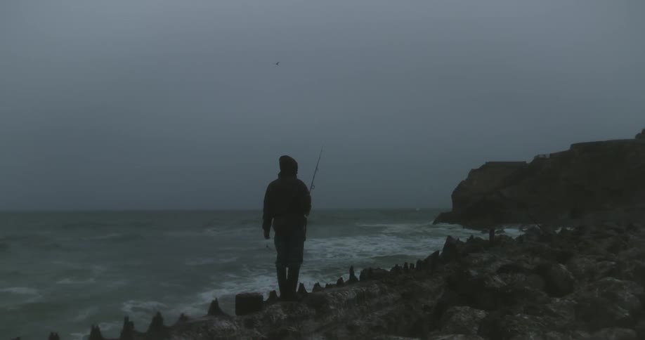 Man stands and fishes at dusk