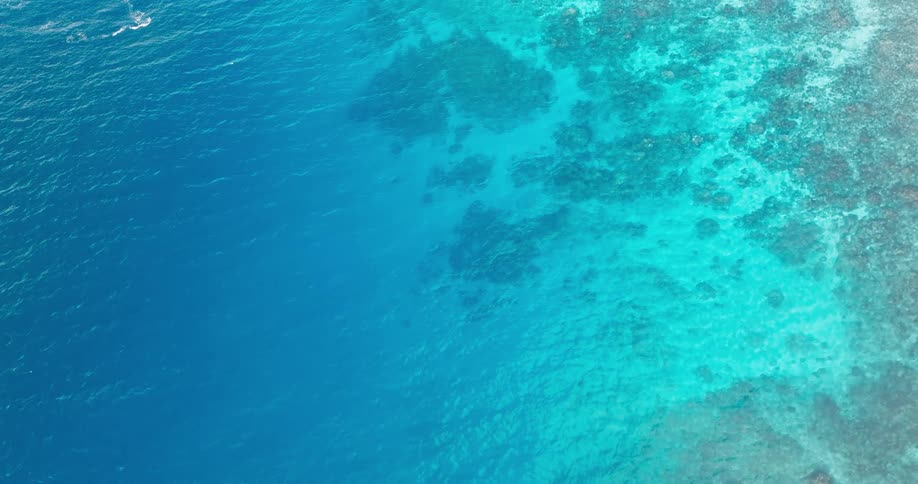 Coral reefs are visible under crystal clear blue water