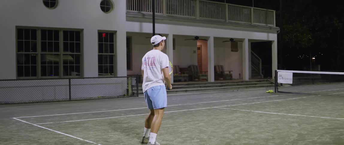A man plays tennis on an outdoor court