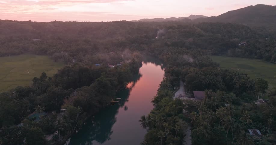 View of a river with some small houses in the middle of nature