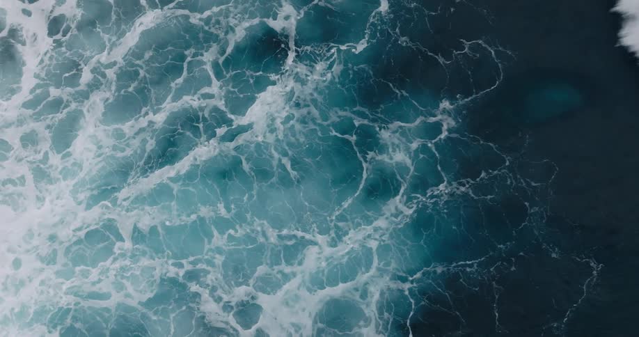 Birds eye view of waves crashing in the ocean