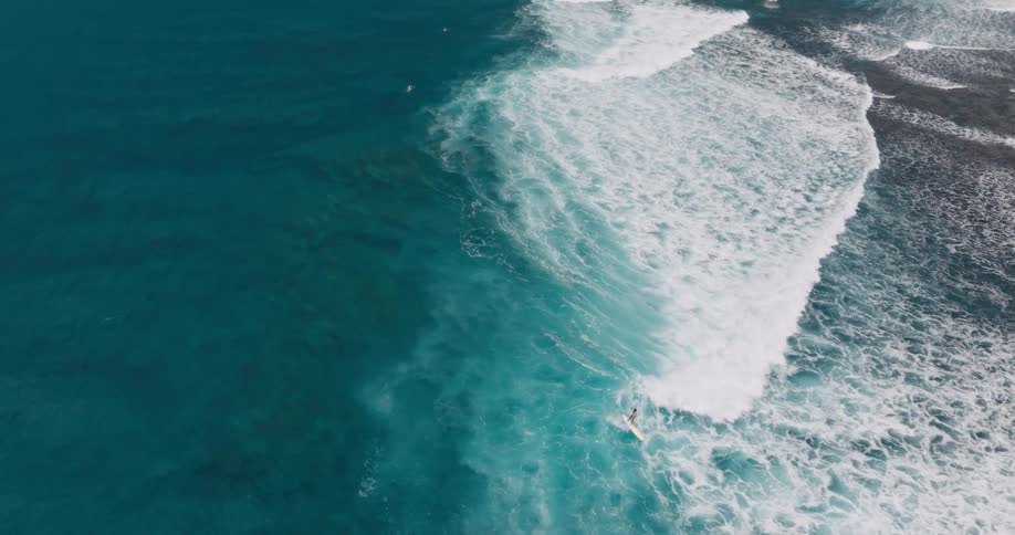 A surfer rides the tide towards the shore