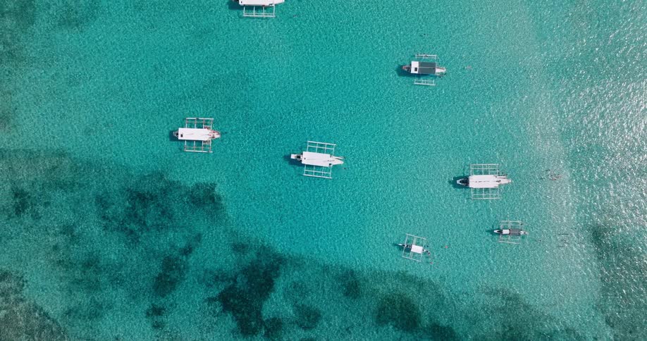 Boats floating in the shallow end of the ocean