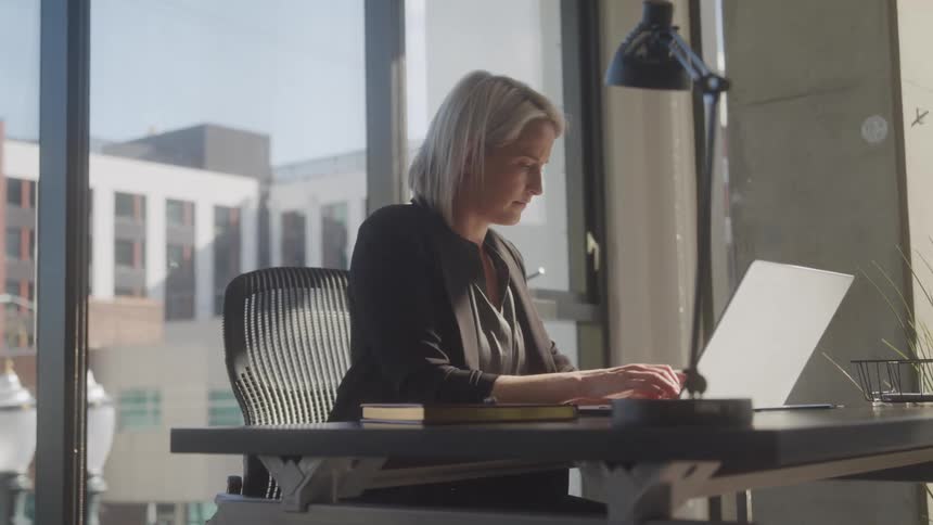 A footage of a lady typing in the office
