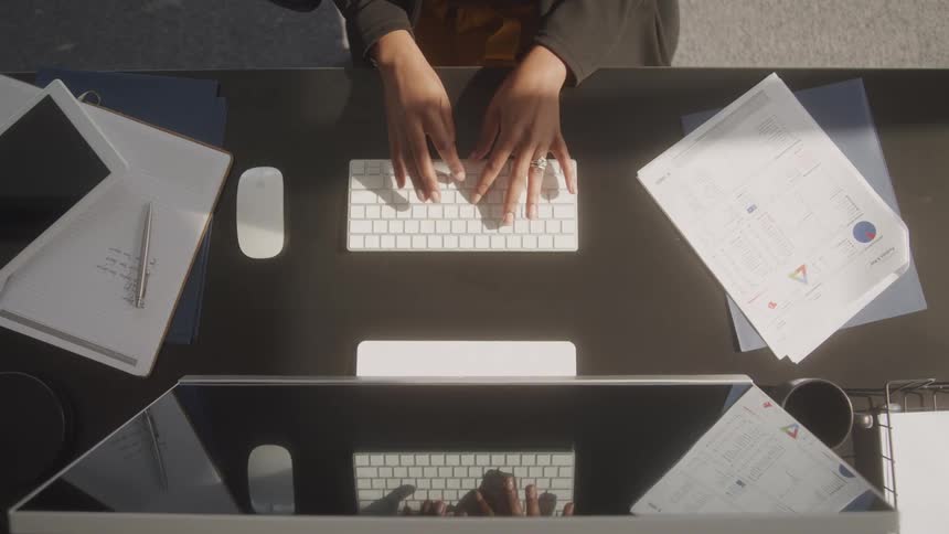 A woman is typing on her keyboard in the office