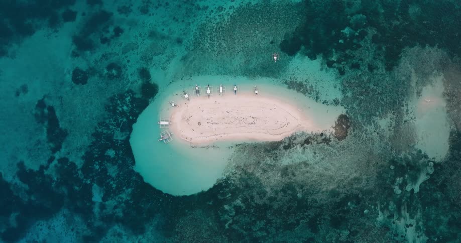 Boats are docked on the sand of the very small island