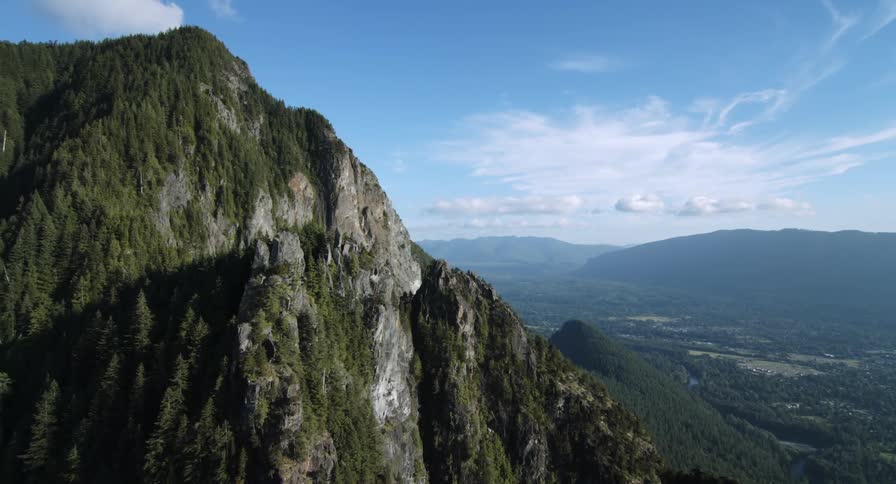 The tall mountain is covered with green