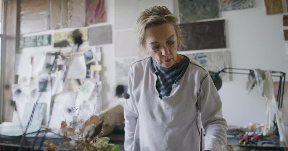 A woman is painting in her studio
