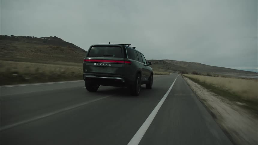 The sports utility vehicle drives on the road by the mountain