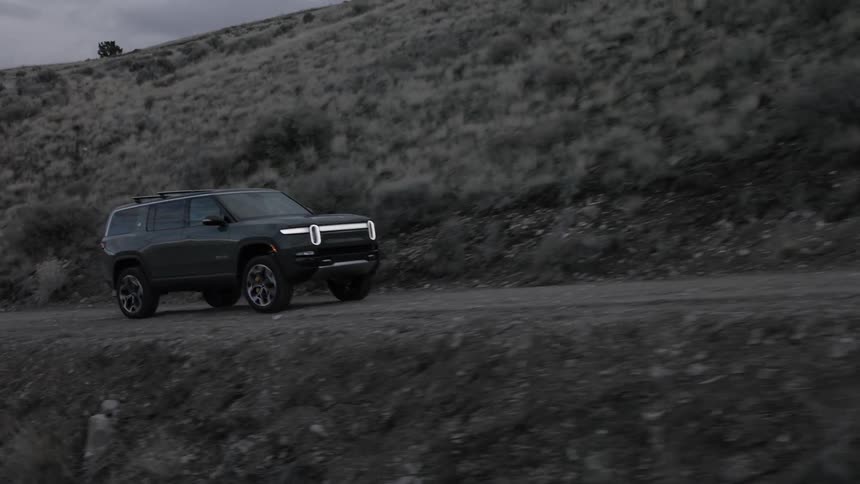 On an empty rural road a person is driving a vehicle