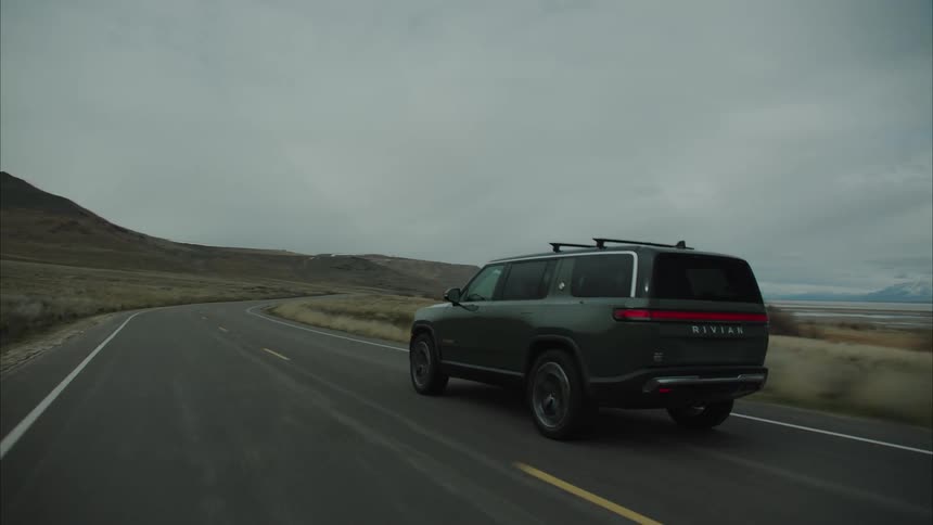 The vehicle drives on the winding road on a cloudy day