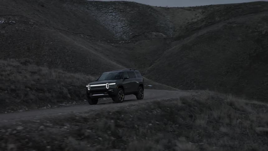 A car is driving on a landscape of rocky terrain