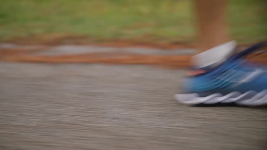Outdoors in the spring time a person is jogging by themselves