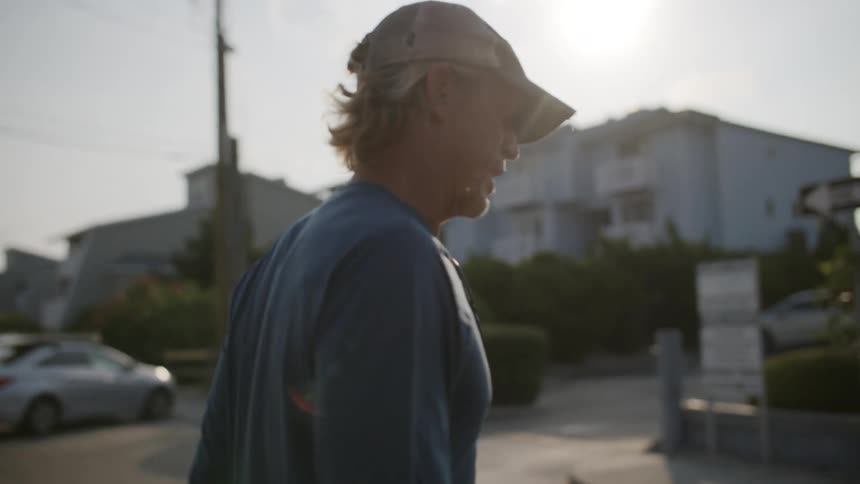 A man is walking outdoors by himself in a suburban city