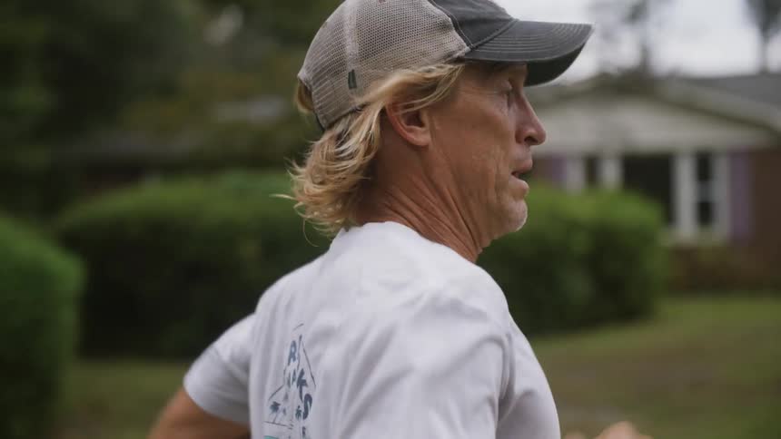 A man is jogging outdoors in a suburban neighborhood