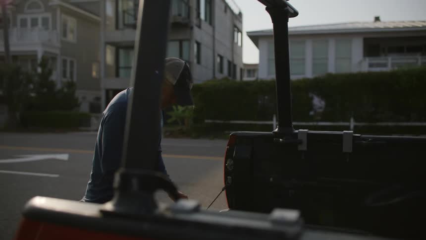 A man is packing stuff into his truck bed